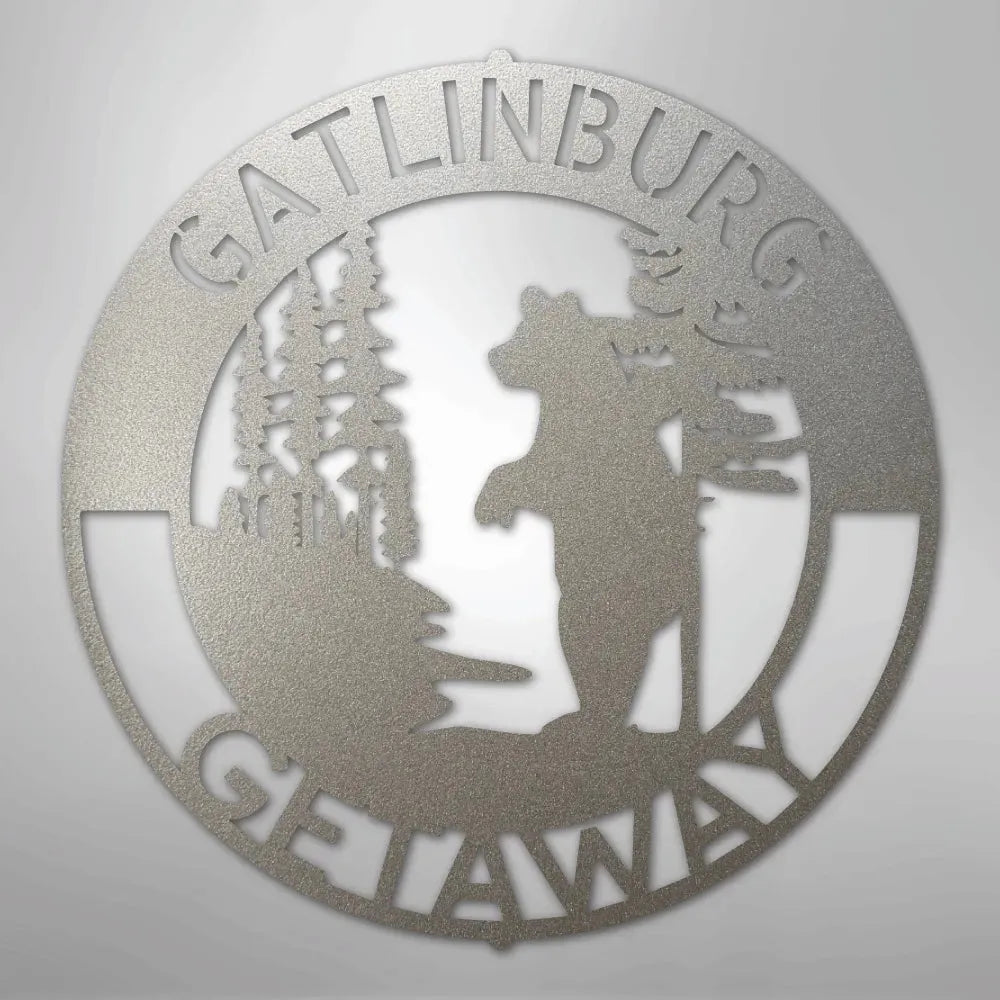 Silver metal wall art with "Gatlinburg Getaway" text, featuring a bear, trees, and mountains.