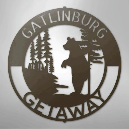 Brown metal wall art: "Gatlinburg Getaway" text encircles a bear standing among pine trees.