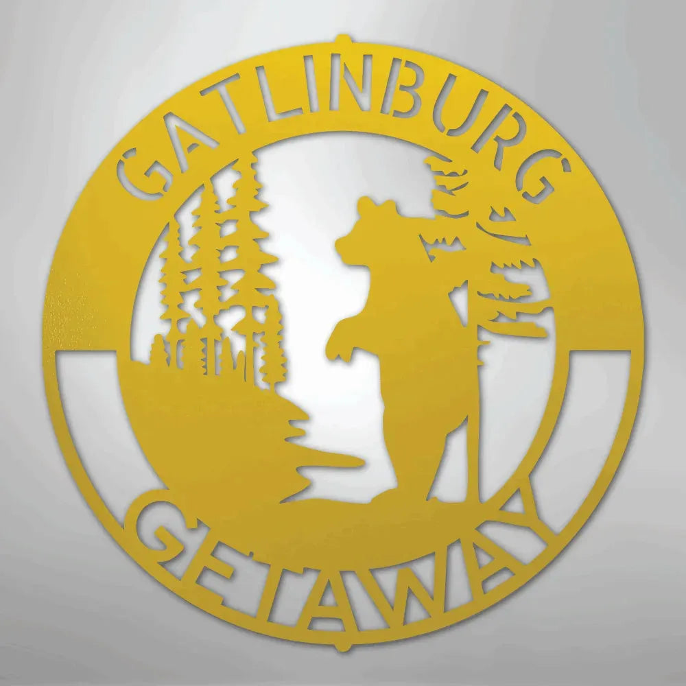 Gold metal wall art with "Gatlinburg Getaway" text, a bear, and pine trees.
