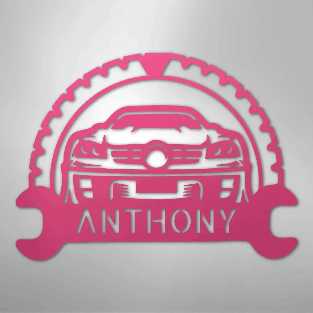 Pink metal classic car monogram with "ANTHONY" text, framed by a gear and wrenches.