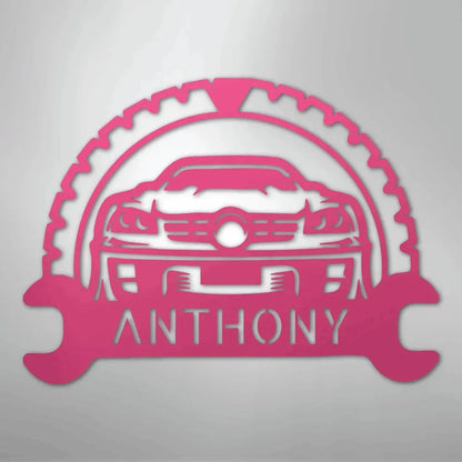 Pink metal classic car monogram with "ANTHONY" text, framed by a gear and wrenches.