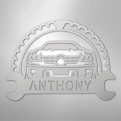 Silver metal classic car monogram with "ANTHONY" text, gear, and wrenches.
