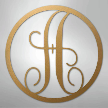 Gold metal wall art with a fancy script initial "A" inside a circular frame.