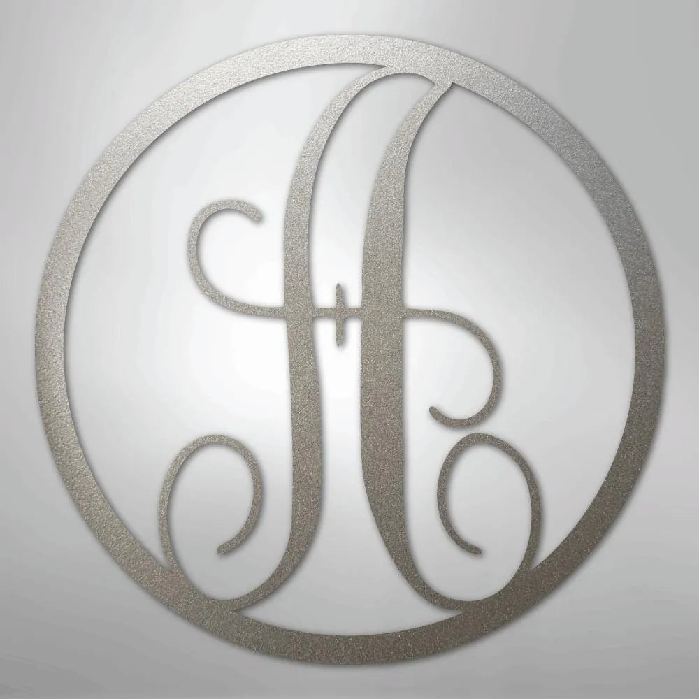 Silver metal wall art with a fancy script initial "H" inside a circular frame.