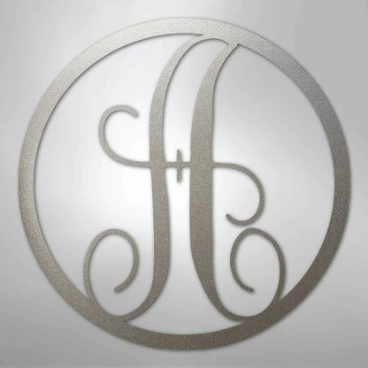 Silver metal wall art with a fancy script initial "H" inside a circular frame.