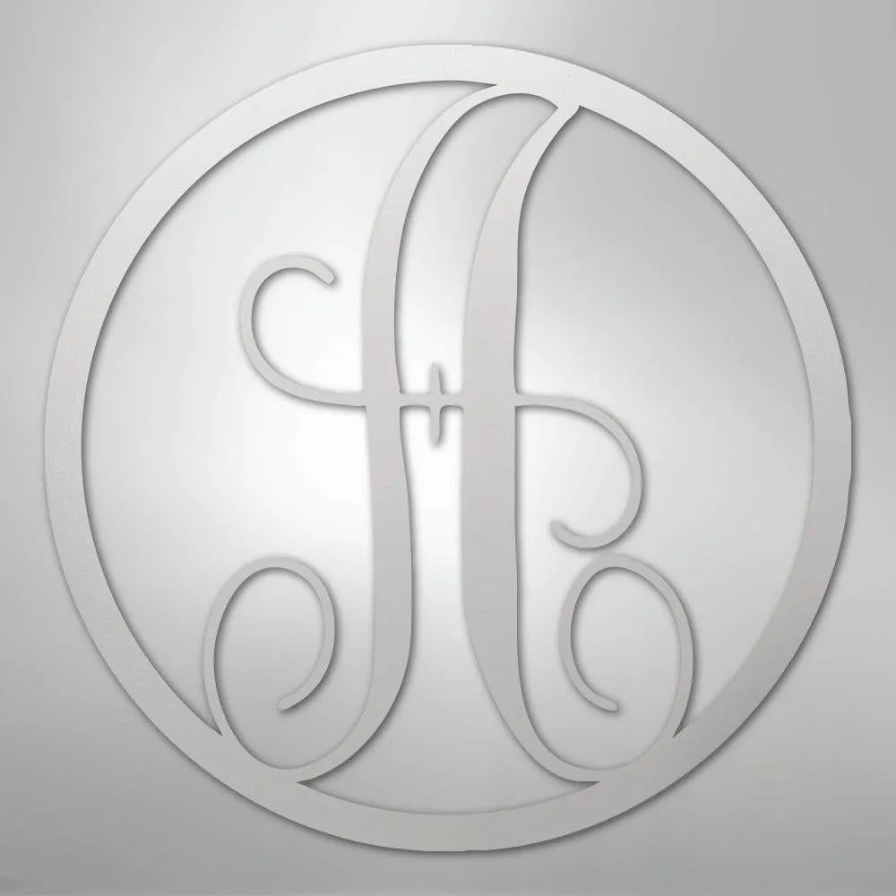 Silver metal wall art with a fancy script initial "A" inside a circular frame.