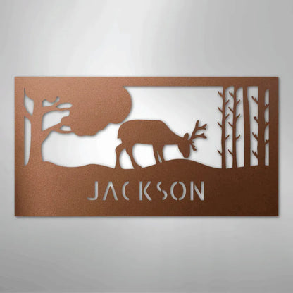 Copper metal wall art with a grazing deer, trees, and "JACKSON" cut out.
