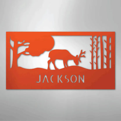 Orange metal wall art with a grazing deer, trees, and "JACKSON" cut out below.