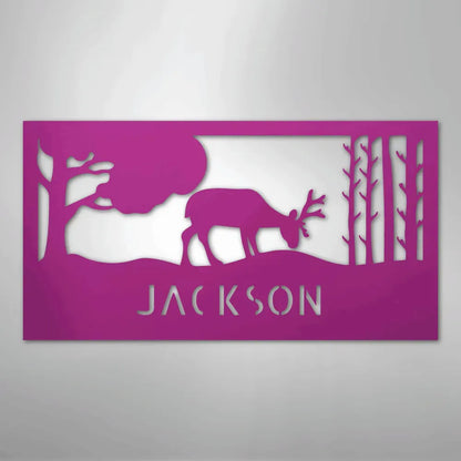 Pink metal wall art with a grazing deer, trees, and "JACKSON" cut out below.