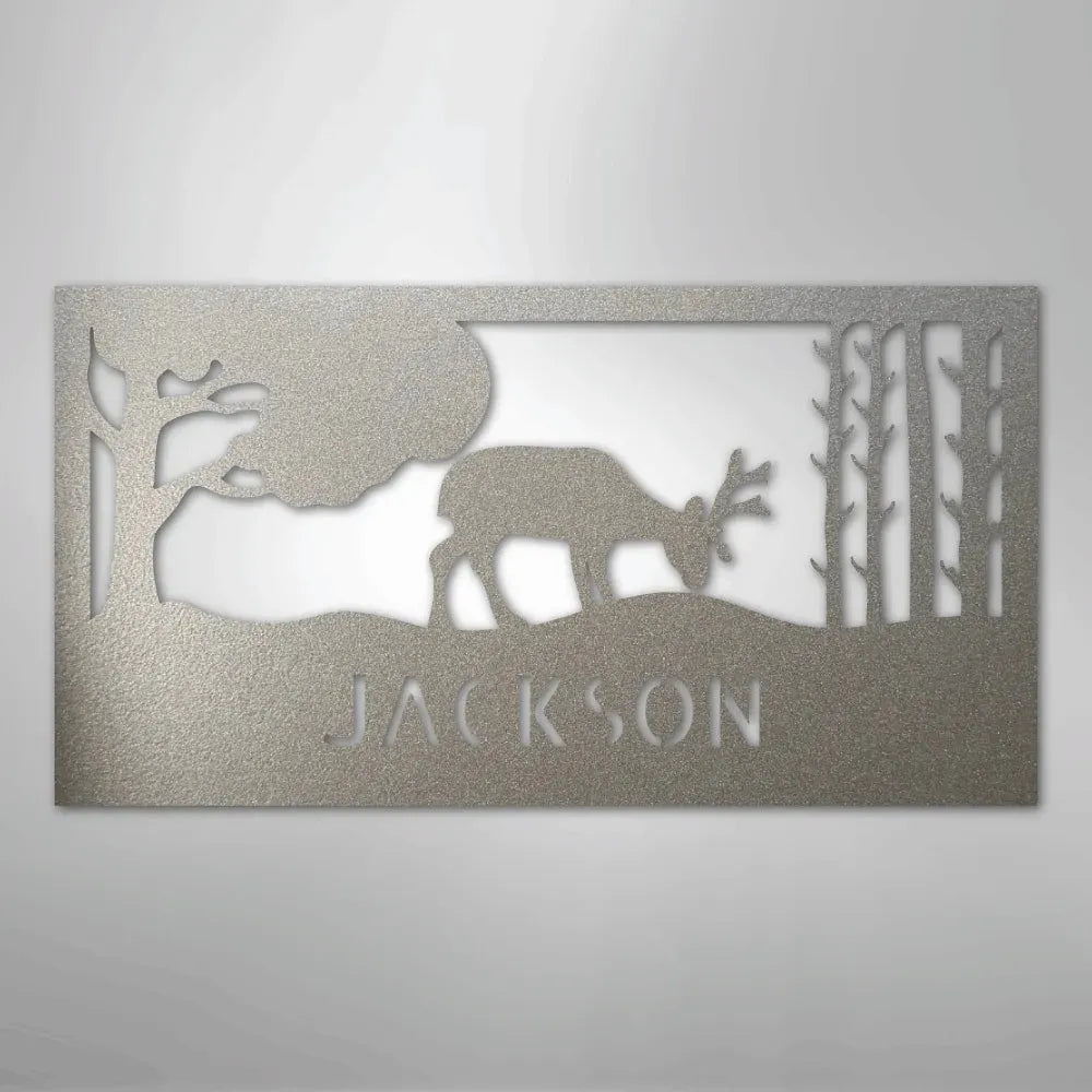 Silver metal wall art featuring a grazing deer, trees, and "JACKSON" cutout.