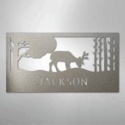 Silver metal wall art featuring a grazing deer, trees, and "JACKSON" cutout.