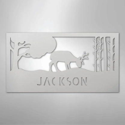 White metal wall art featuring a grazing deer, trees, and "JACKSON" cut out below.