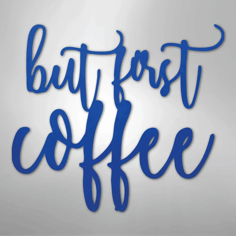 Blue metal wall art with "but first coffee" in a script font.