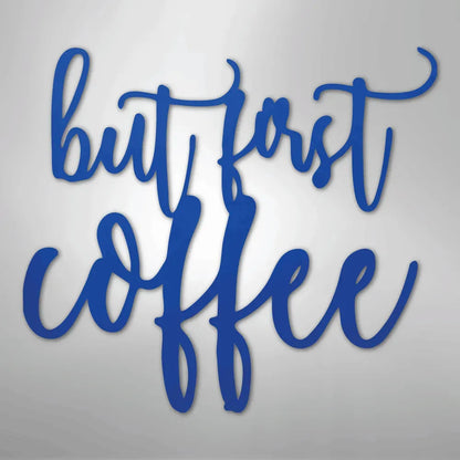 Blue metal wall art with "but first coffee" in a script font.