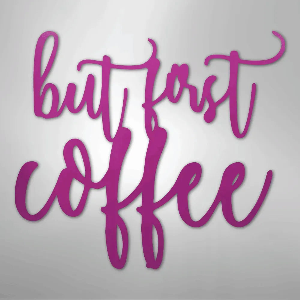 Pink "but first coffee" metal wall art in a script font.