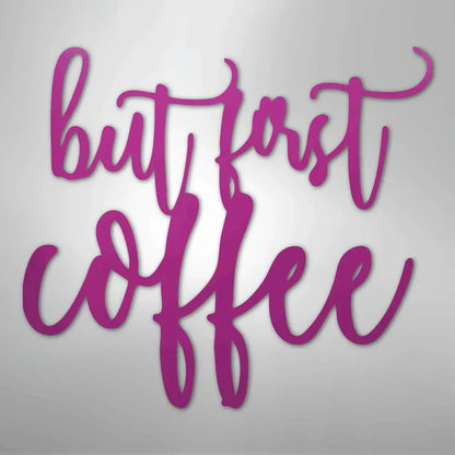 Pink "but first coffee" metal wall art in a script font.