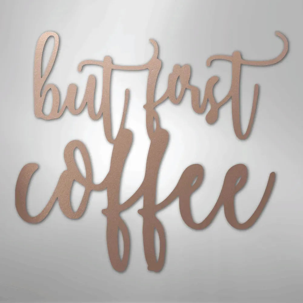 Rose gold metal wall art with "but first coffee" in elegant script.
