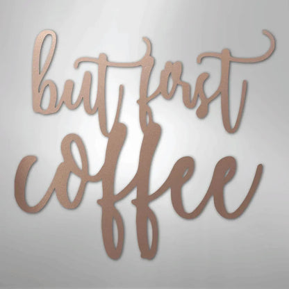 Rose gold metal wall art with "but first coffee" in elegant script.