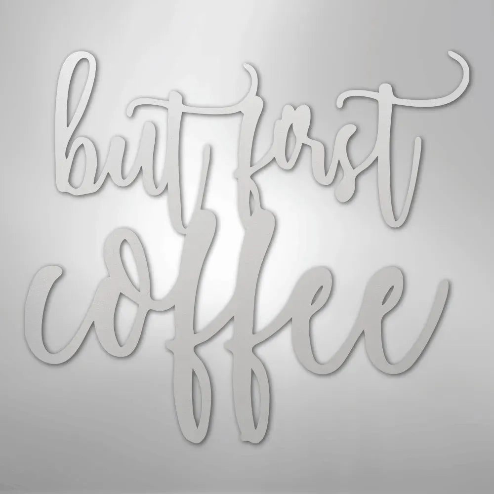 Silver metal wall art with "but first coffee" in elegant script.