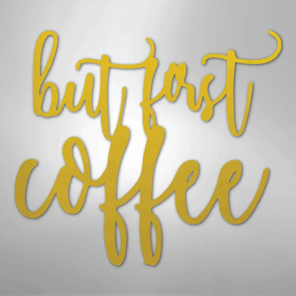 Gold metal wall art with "but first coffee" in elegant script.