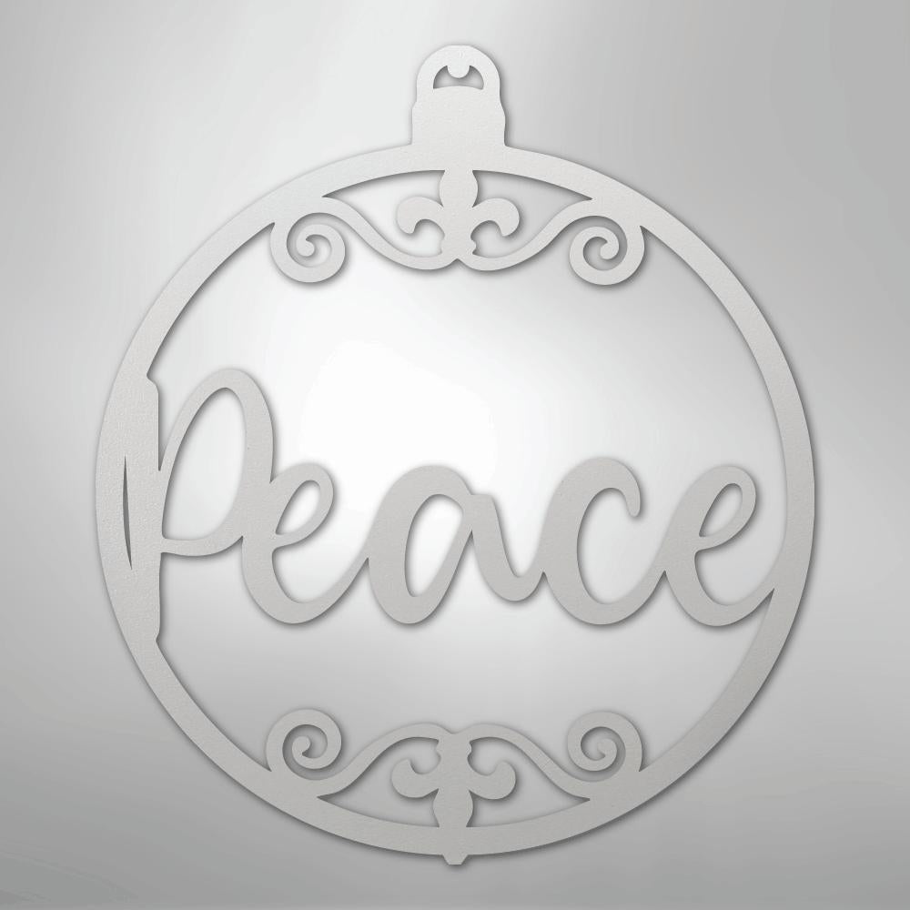 White metal Christmas ornament wall art with "Peace" in script and decorative swirls.