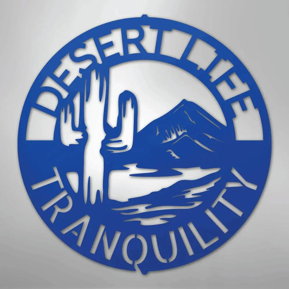 Blue metal wall art with "Desert Life Tranquility" text, saguaro cactus, and mountain silhouette.