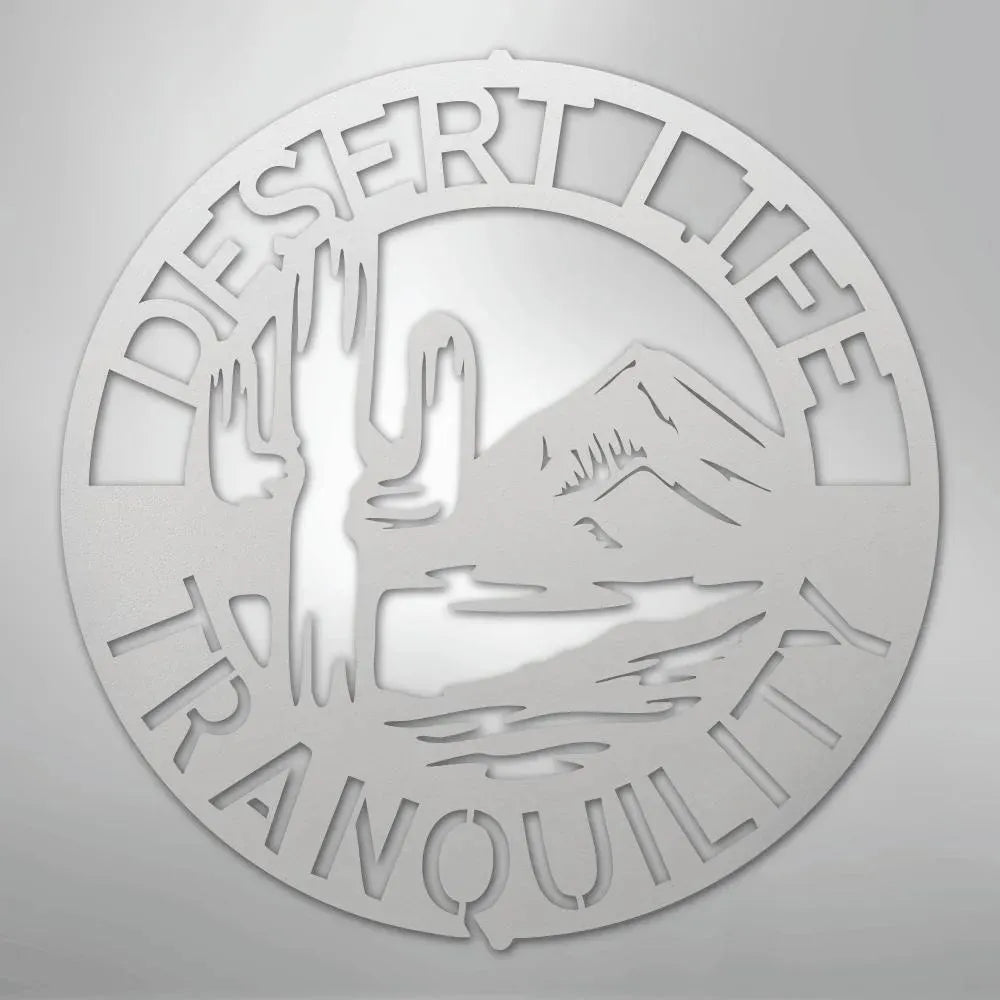 Round silver metal wall art with "DESERT LIFE TRANQUILITY" text, saguaro cactus, and mountains.