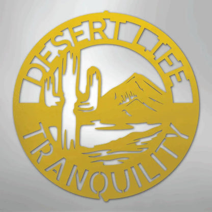 Round gold metal wall art with "Desert Life Tranquility" text, saguaro cactus, and mountain landscape design.