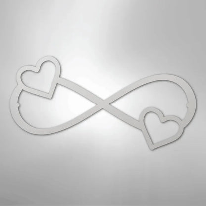 White metal infinity symbol wall art with two hearts, one on each end.