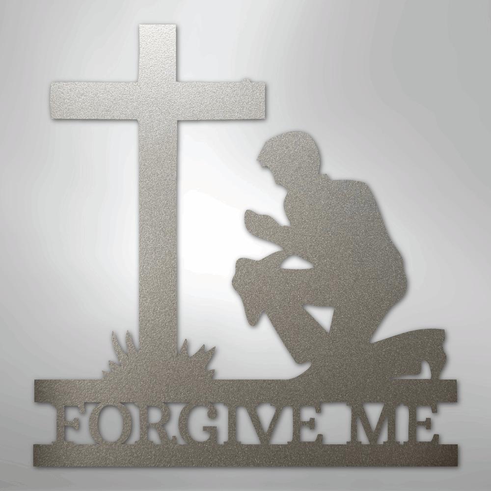 Silver metal wall art depicting a kneeling man praying before a cross, with "FORGIVE ME" cut out below.