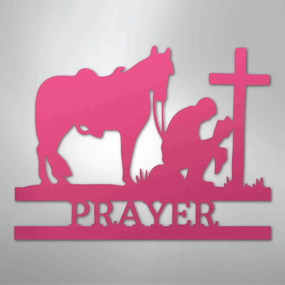 Pink metal wall art: cowboy kneeling by a cross with a horse, "PRAYER" below.