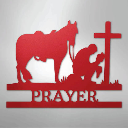 Red metal wall art: cowboy kneeling by a cross with a horse, "PRAYER" below.