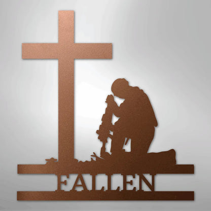 Copper metal wall art depicting a kneeling soldier with a rifle before a cross, with "FALLEN" below.