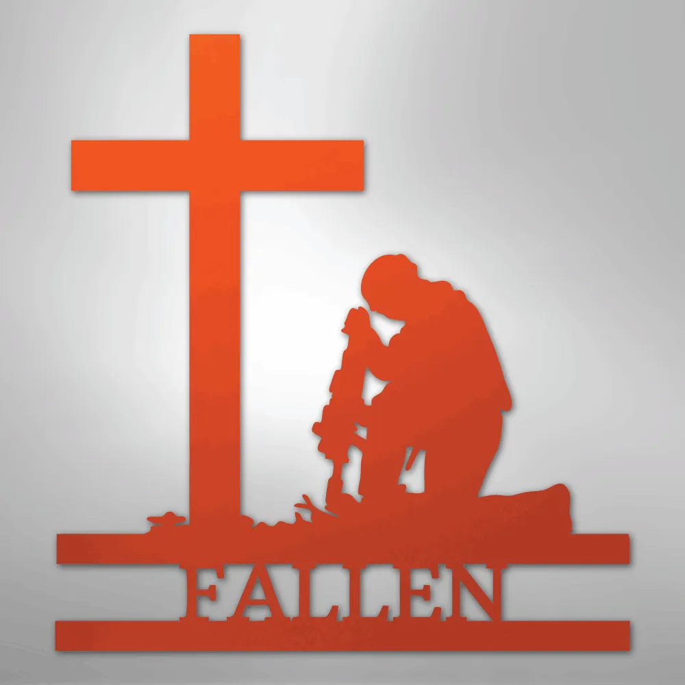 Orange metal wall art depicting a kneeling soldier with a rifle before a cross, "FALLEN" below.