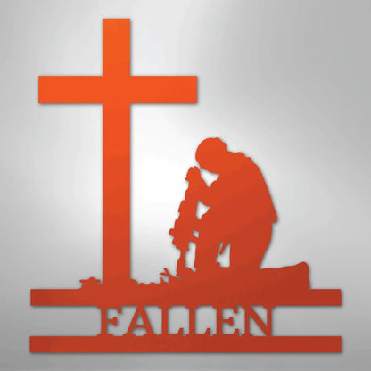 Orange metal wall art depicting a kneeling soldier with a rifle before a cross, "FALLEN" below.