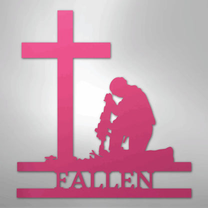 Pink metal wall art of a kneeling soldier silhouette with a cross and "FALLEN" text.
