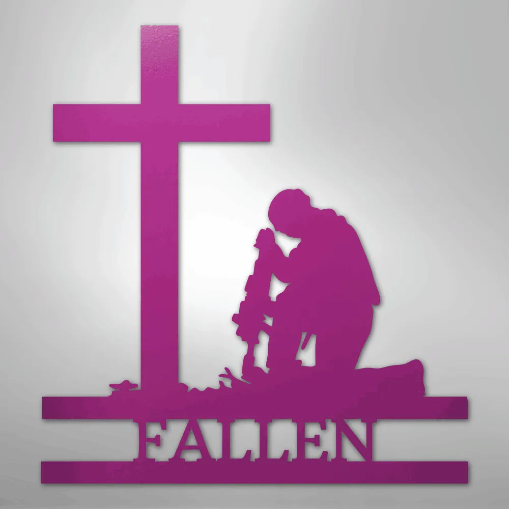 Pink metal wall art of a kneeling soldier silhouette before a cross, with "FALLEN" below.