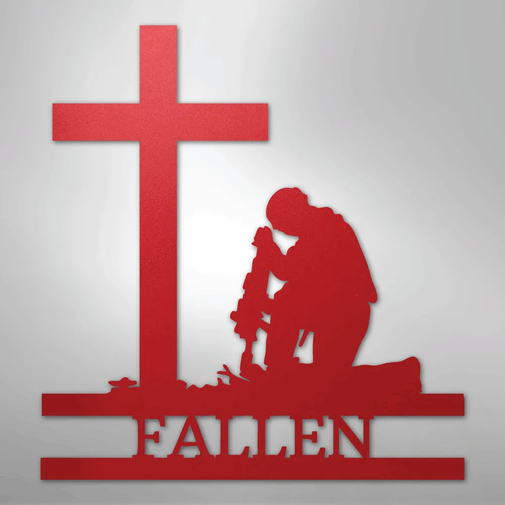 Red metal wall art of a kneeling soldier silhouette with rifle, cross, and "FALLEN" text.