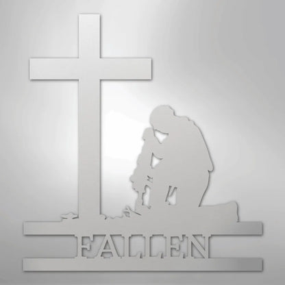 White metal wall art depicting a kneeling soldier silhouette before a cross, with "FALLEN" cut out below.