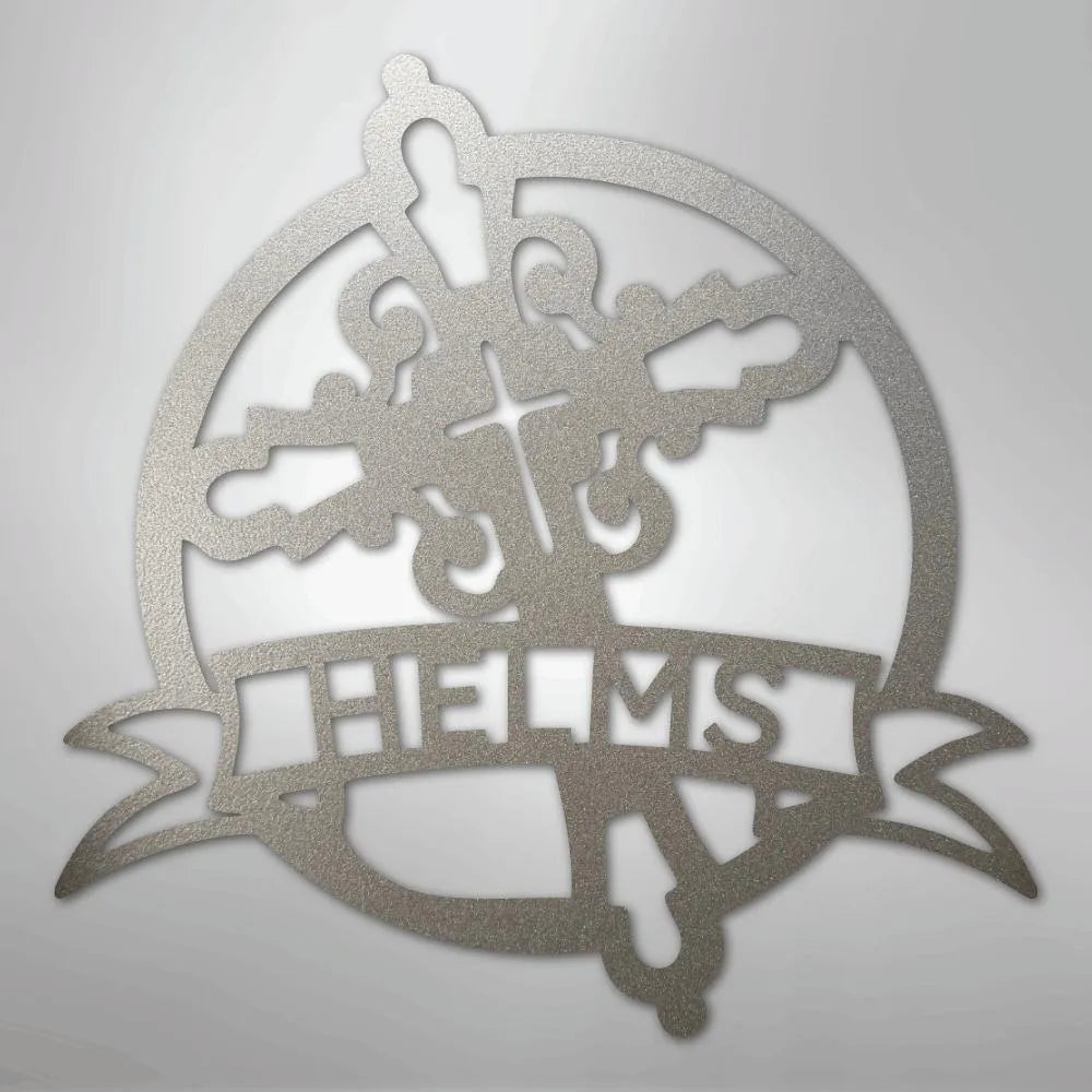 Silver Catholic monogram metal wall art with a cross, ornate flourishes, and "HELMS" on a banner.