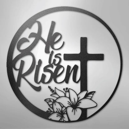 Black metal "He is Risen" wall art with a cross and lilies in a circular design.