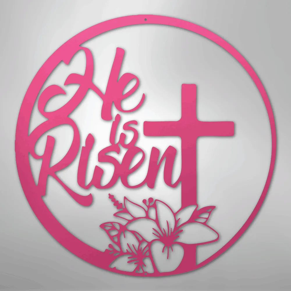 Pink "He is Risen" metal wall art with a cross and lilies inside a circular frame.