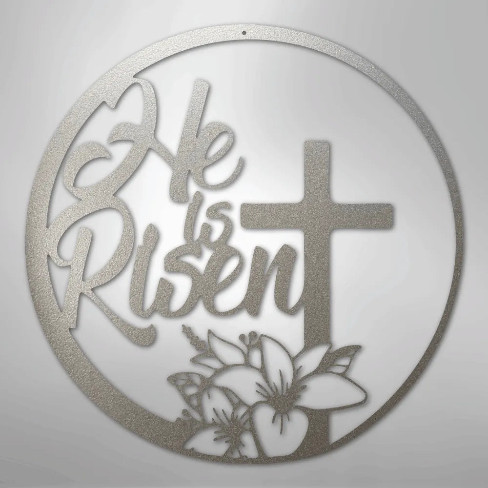Silver "He is Risen" metal wall art with a cross and lilies in a circular design.