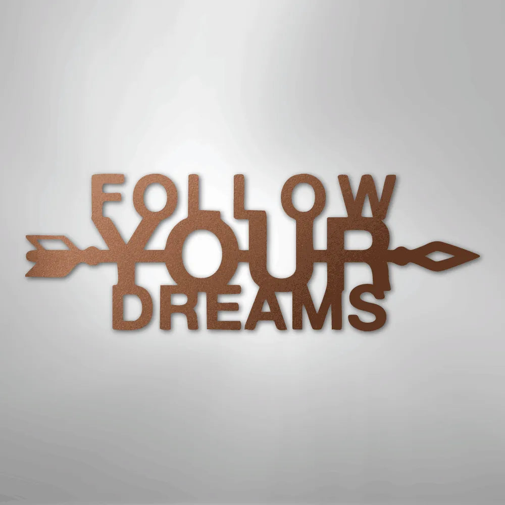 Copper "Follow Your Dreams" metal wall art with an arrow design, casting a shadow on a light background.