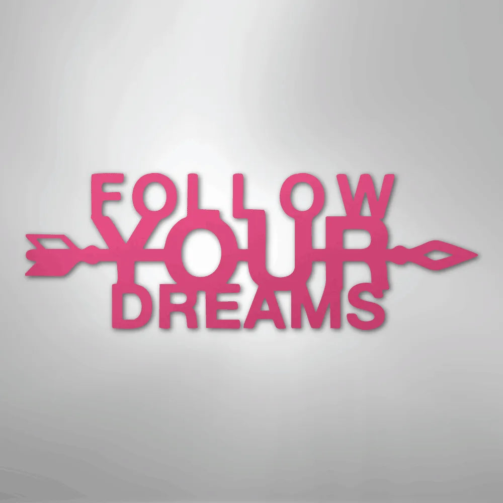 Pink metal wall art spelling "FOLLOW YOUR DREAMS" with an arrow design.