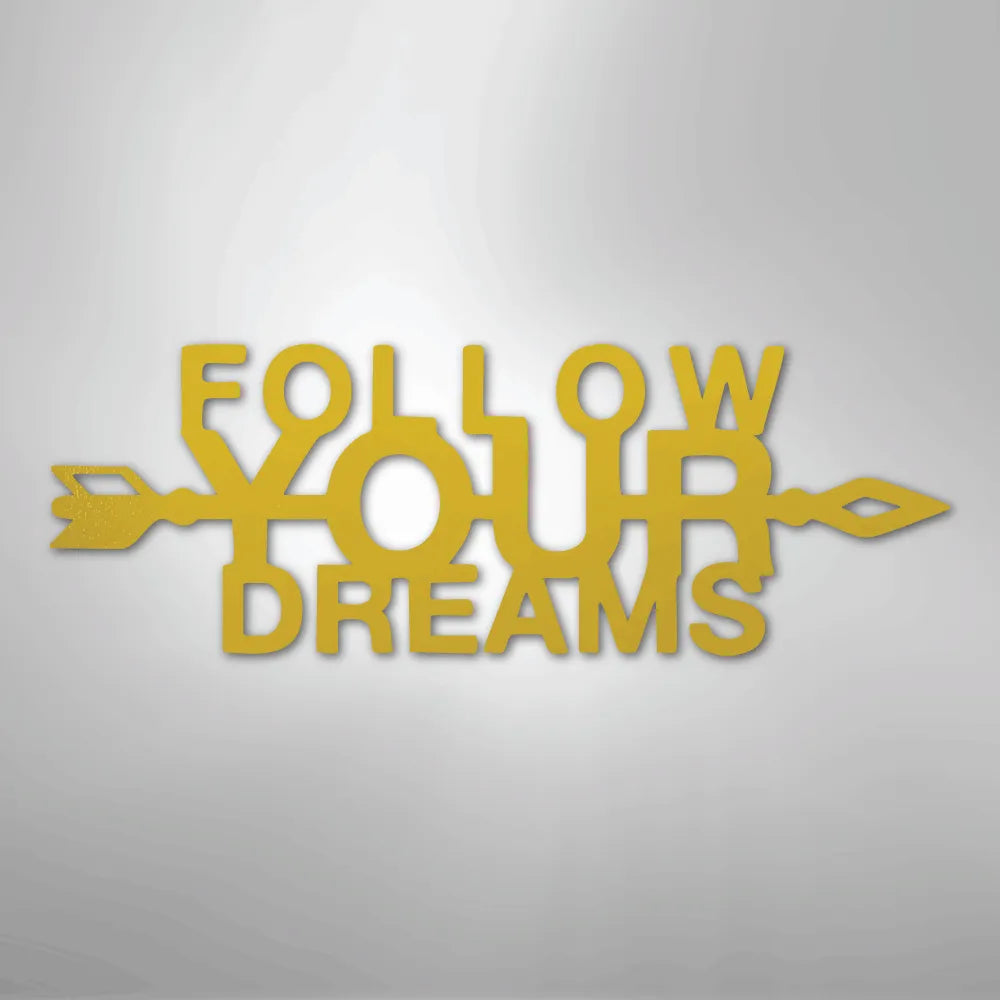 Gold metal wall art spelling "FOLLOW YOUR DREAMS" with an arrow design.