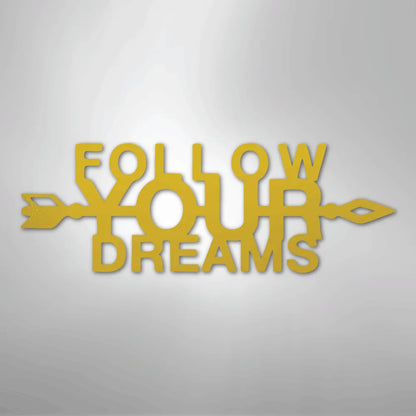 Gold metal wall art spelling "FOLLOW YOUR DREAMS" with an arrow design.