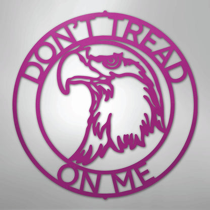 Pink metal wall art with an eagle head inside a circle, text "DON'T TREAD ON ME".