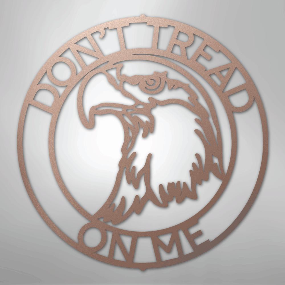 Rose gold metal wall art with "Don't Tread On Me" text and an eagle head in a circular design.