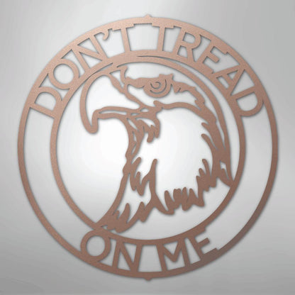 Rose gold metal wall art with "Don't Tread On Me" text and an eagle head in a circular design.
